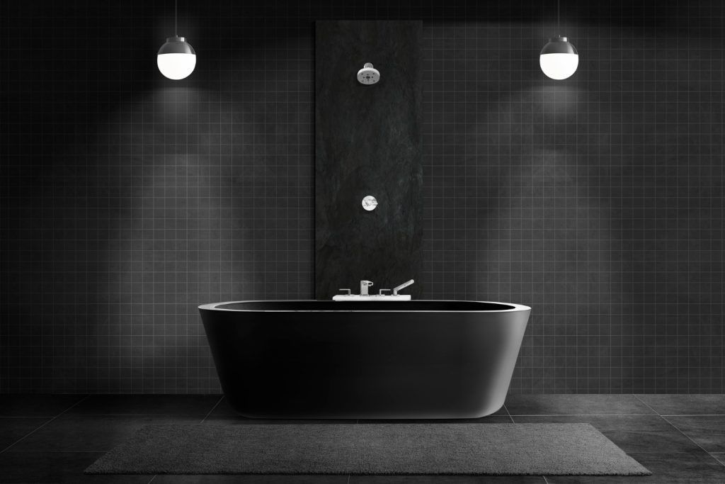 Cadă freestanding neagră într-un decor de baie modern, cu faianță neagră și iluminare suspendată